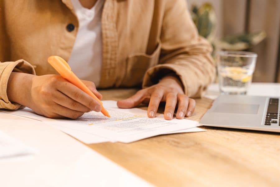 A postgraduate student reading a journal article with a highlighter in hand.