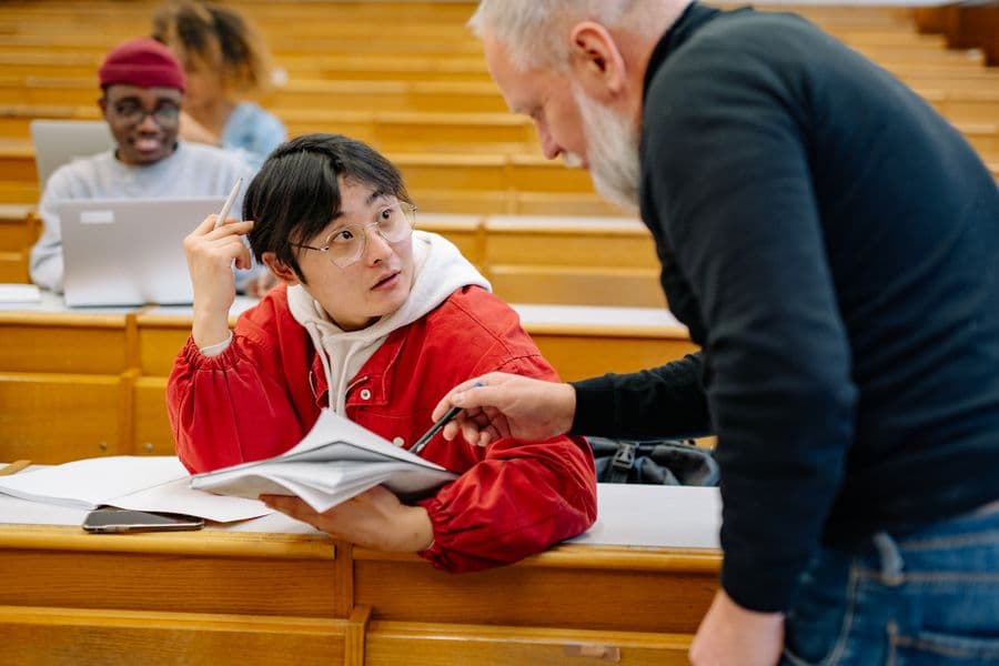A supervisor and a student reviewing a printed chapter together.