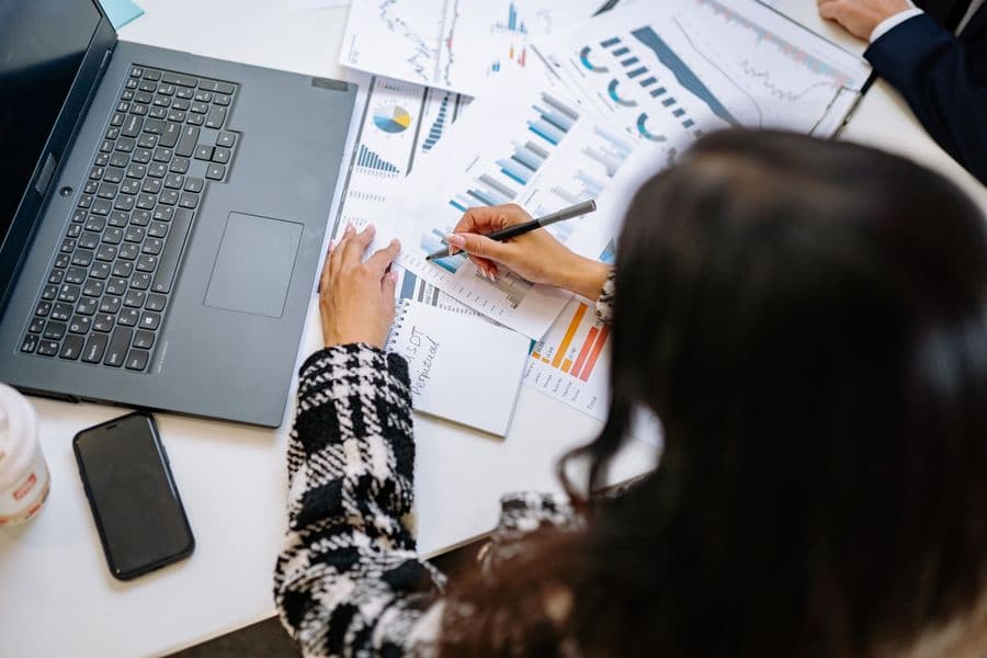 Charts and analysis notes spread across a desk.